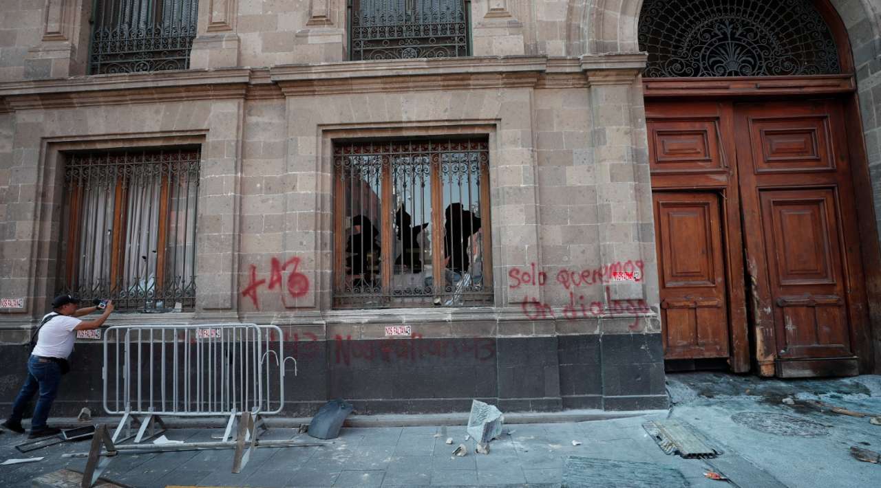 Manifestantes derriban puerta de Palacio Nacional en apoyo a padres de los 43 de Ayotzinapa