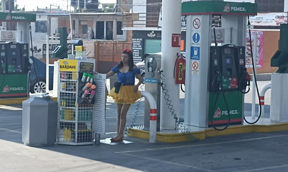 Trabajadores de una gasolinera se caracterizan para festejar el Día de la Niñez