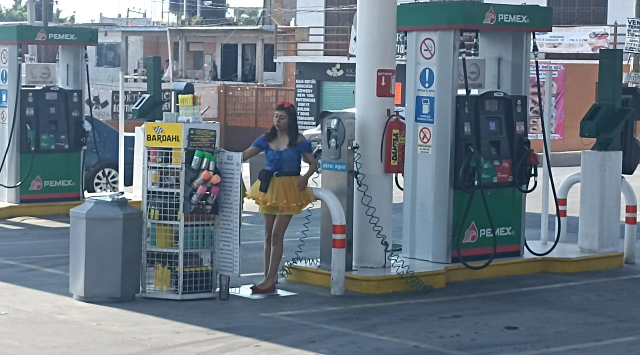 Trabajadores de una gasolinera se caracterizan para festejar el Día de la Niñez