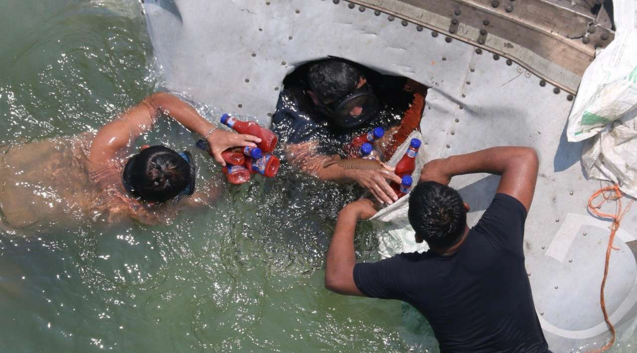 Rapiña bajo el agua: pobladores de Tabasco bucean para obtener mercancía de tráiler accidentado en un río